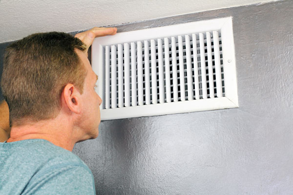 Man checking the air vents in his home
