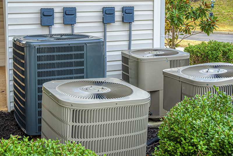 Four AC units of varying size outside of a building