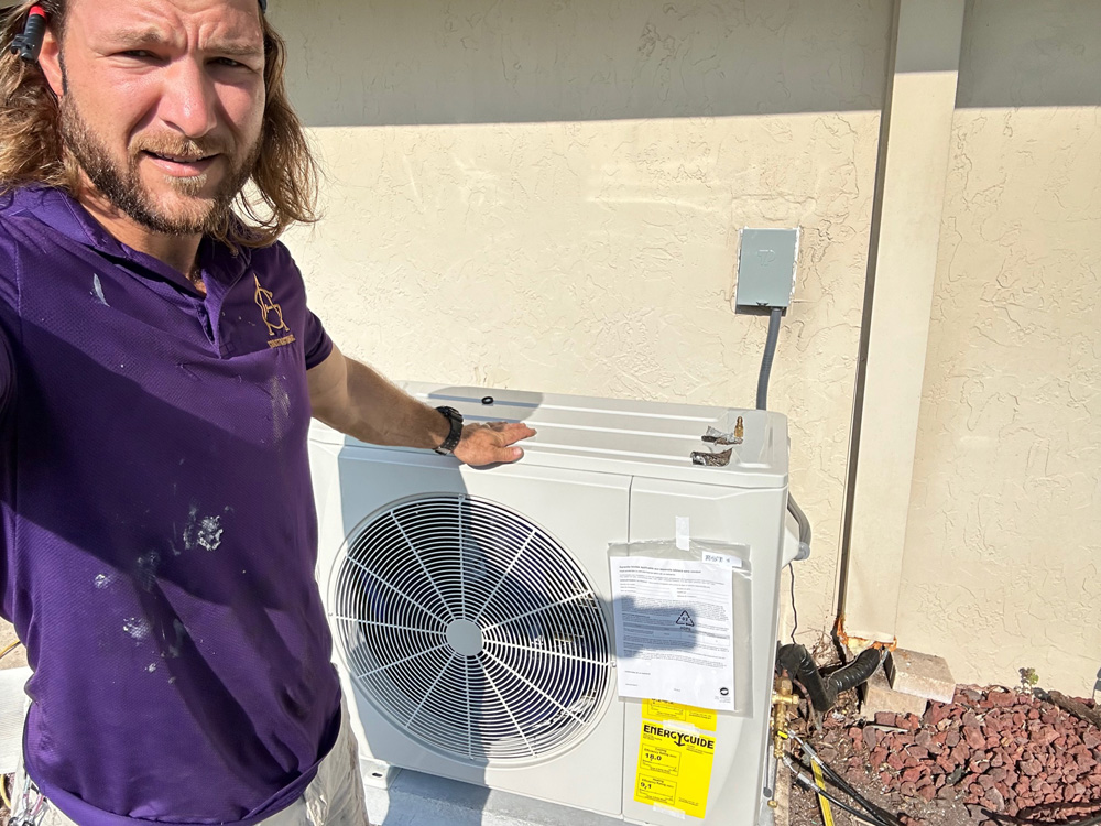 Jimmy, Owner of A&G Air Conditioning, standing in front of a residential air conditioning unit